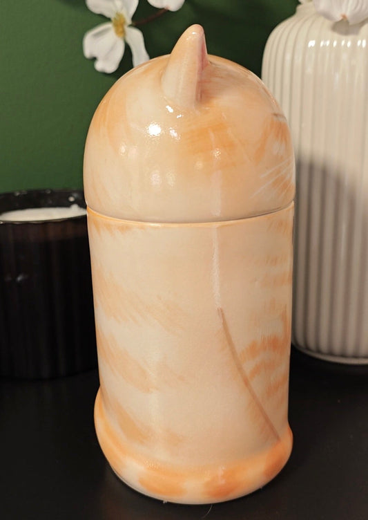 Side view of a hand-painted orange tabby cat ceramic memorial urn