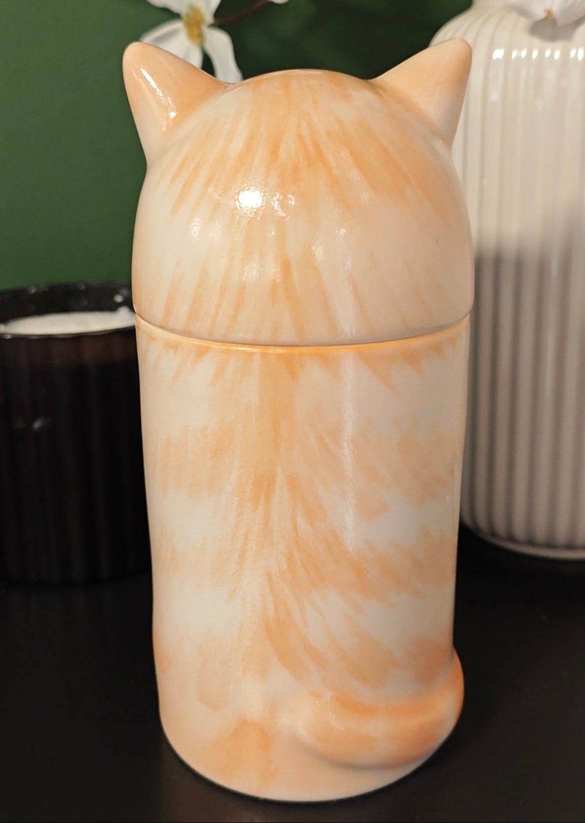 Rear view of a personalized orange tabby cat urn with painted stripes and tail detail