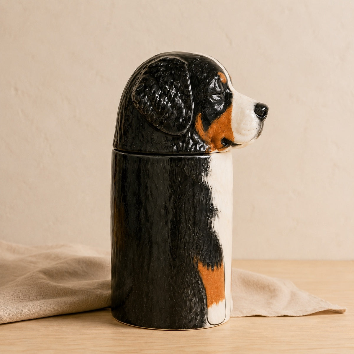 Side profile of a ceramic Bernese Mountain Dog memorial urn facing right