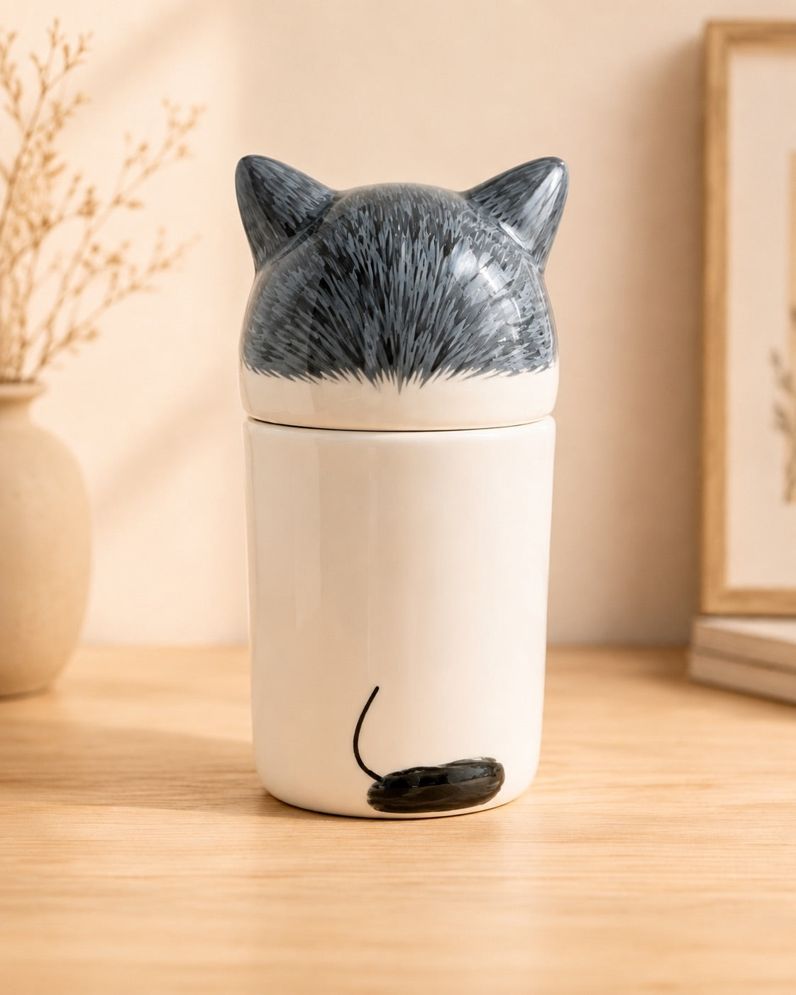 Rear view of a gray and white ceramic cat memorial urn
