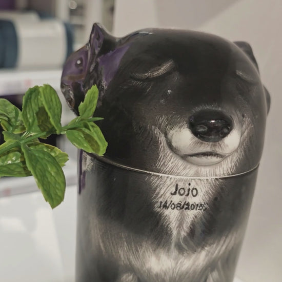 Video showing the front and side details of a personalized black dog ceramic urn for ashes