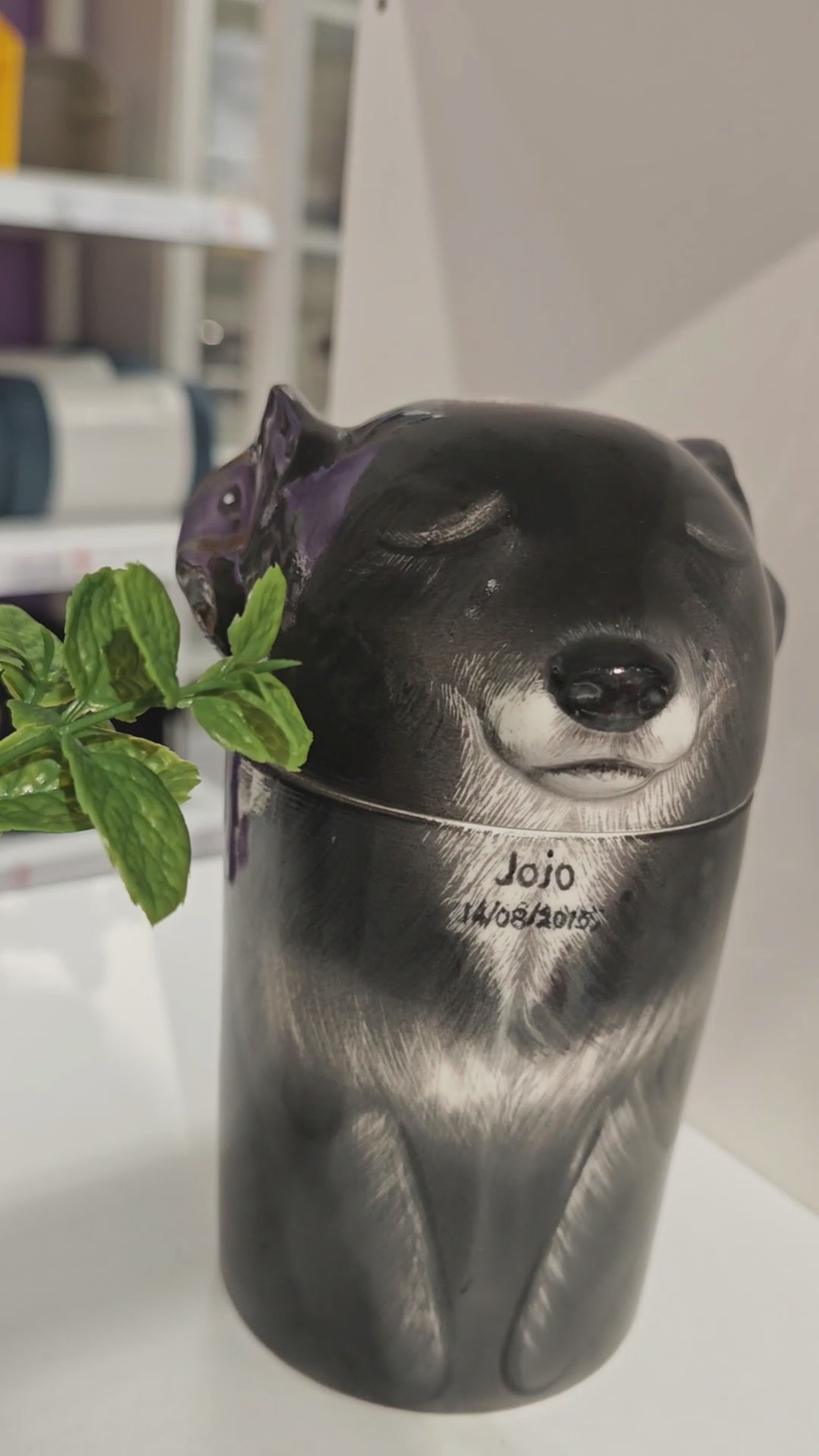 Video showing the front and side details of a personalized black dog ceramic urn for ashes